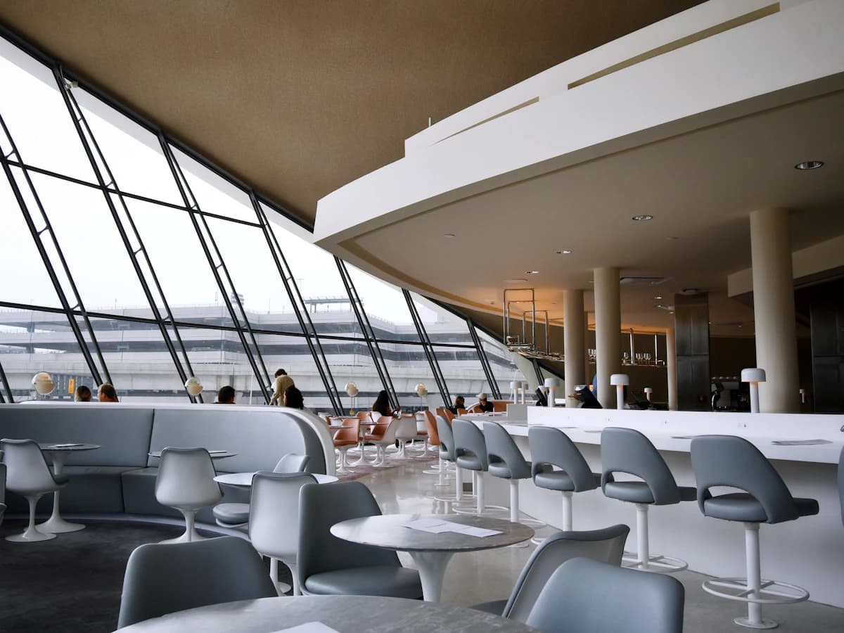 An airport hotel lounge with tall windows and runway views